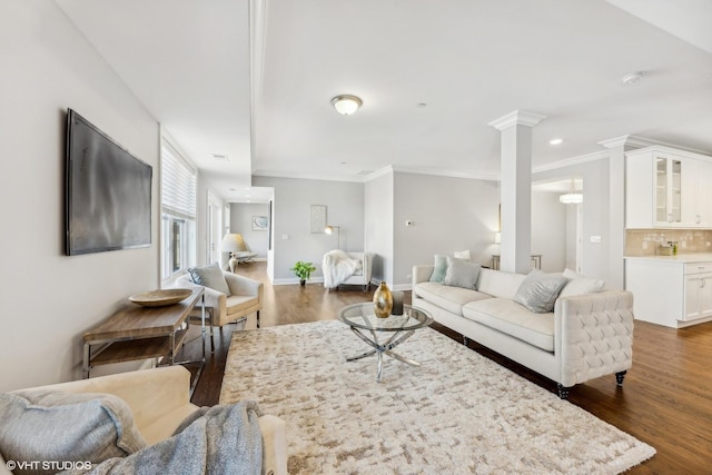 living room featuring decorative columns, crown molding, and dark wood-type flooring