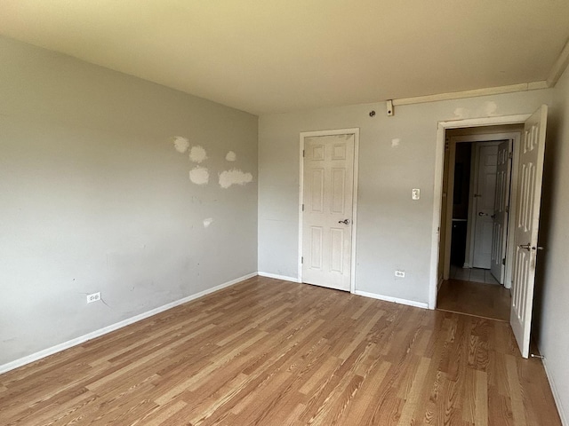 unfurnished bedroom featuring a closet and light wood-type flooring