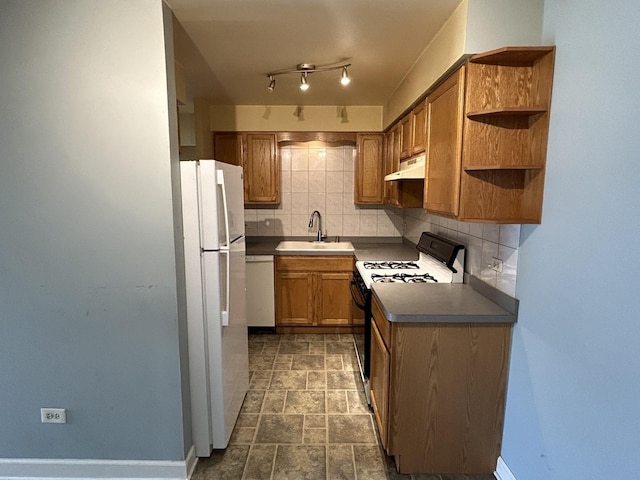 kitchen with decorative backsplash, sink, and white appliances