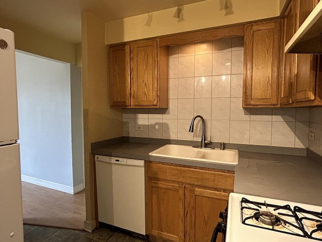 kitchen featuring tasteful backsplash, white appliances, dark wood-type flooring, sink, and range hood