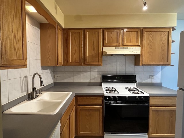 kitchen with backsplash, white range, and sink