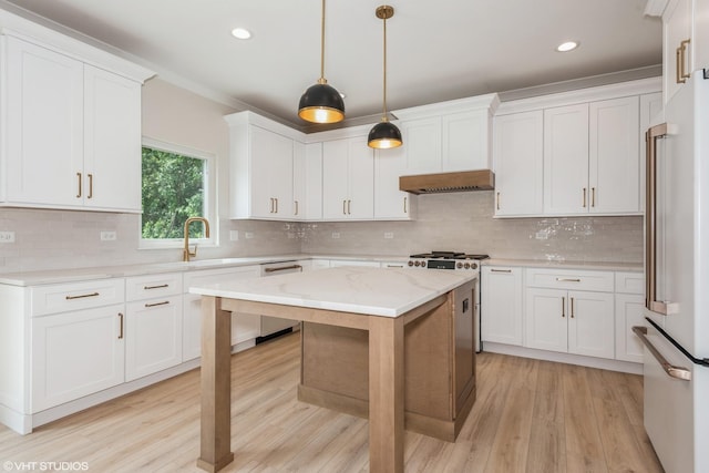 kitchen featuring light stone counters, sink, decorative light fixtures, white cabinets, and a kitchen island