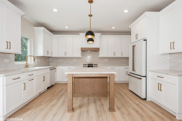 kitchen featuring a center island, white cabinets, decorative light fixtures, and white appliances