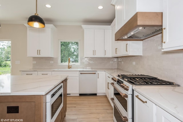 kitchen featuring white appliances, hanging light fixtures, custom range hood, light stone counters, and white cabinetry