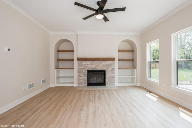 unfurnished living room featuring ceiling fan, built in features, a healthy amount of sunlight, and light hardwood / wood-style floors