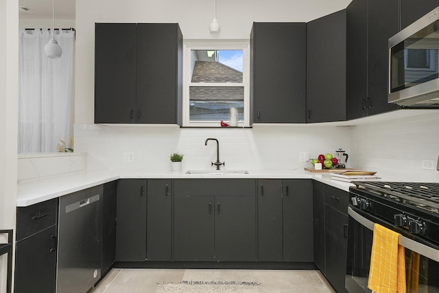 kitchen with light tile patterned flooring, appliances with stainless steel finishes, backsplash, and sink