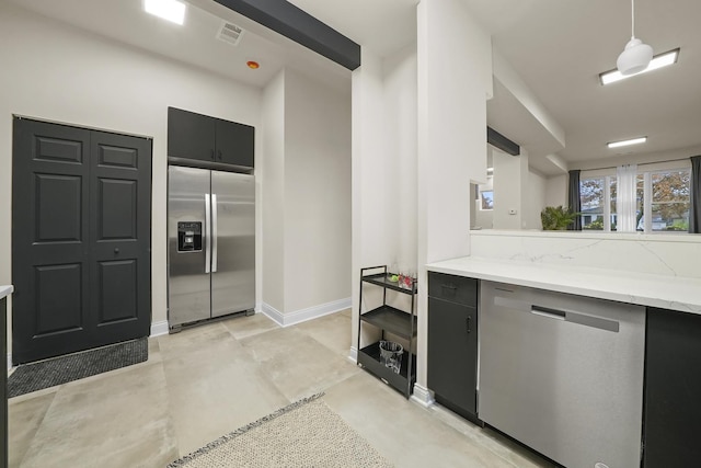 kitchen featuring light stone countertops, stainless steel appliances, and hanging light fixtures