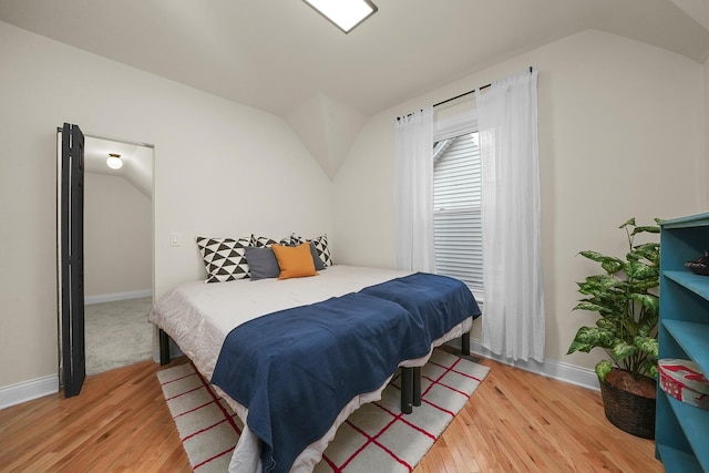 bedroom featuring wood-type flooring and vaulted ceiling