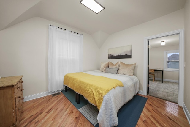 bedroom featuring lofted ceiling and light wood-type flooring