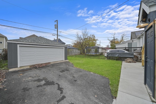 view of yard with a garage and an outbuilding