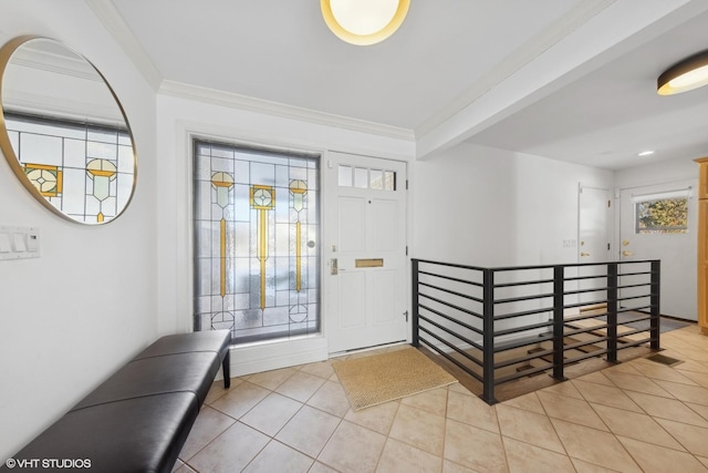 entryway with light tile patterned floors and ornamental molding