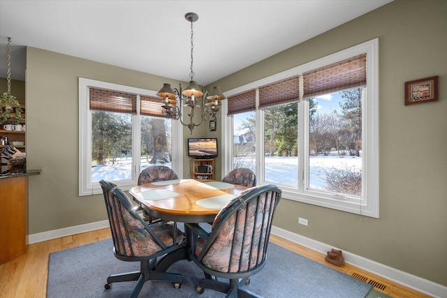 dining area featuring an inviting chandelier and light wood-type flooring