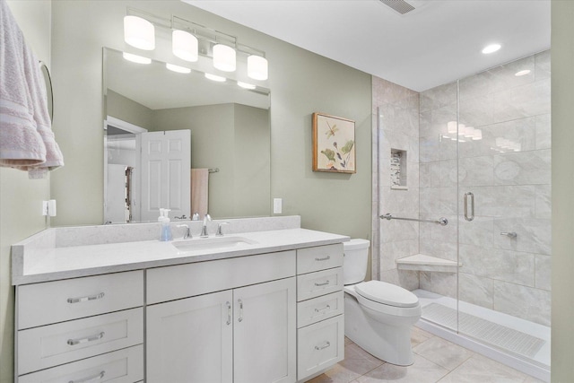 bathroom with toilet, vanity, tile patterned floors, and walk in shower