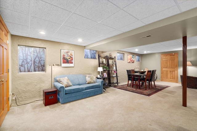 living room featuring a paneled ceiling and carpet flooring