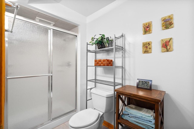 bathroom with toilet, walk in shower, and tile patterned flooring