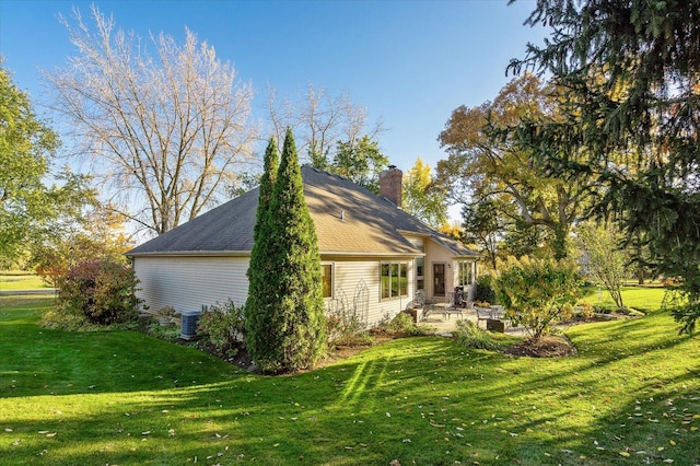 view of side of home featuring a lawn, central air condition unit, and a patio