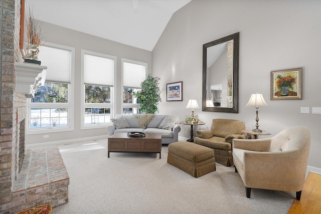 living room with lofted ceiling, a fireplace, and light hardwood / wood-style flooring