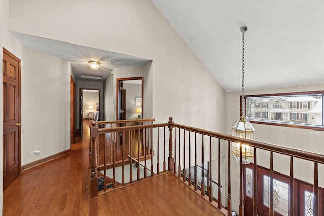 hall with hardwood / wood-style floors and vaulted ceiling