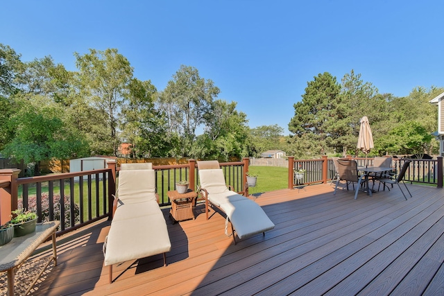 deck with a lawn and a storage shed