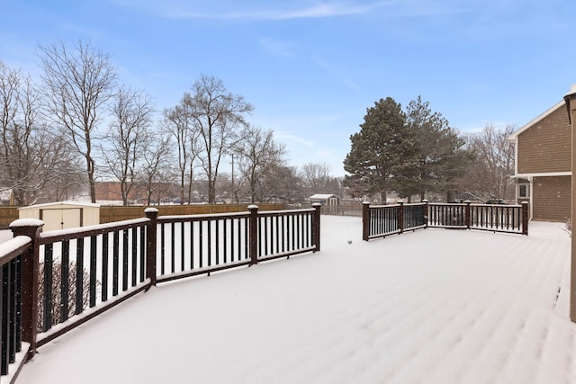 snow covered deck featuring a shed