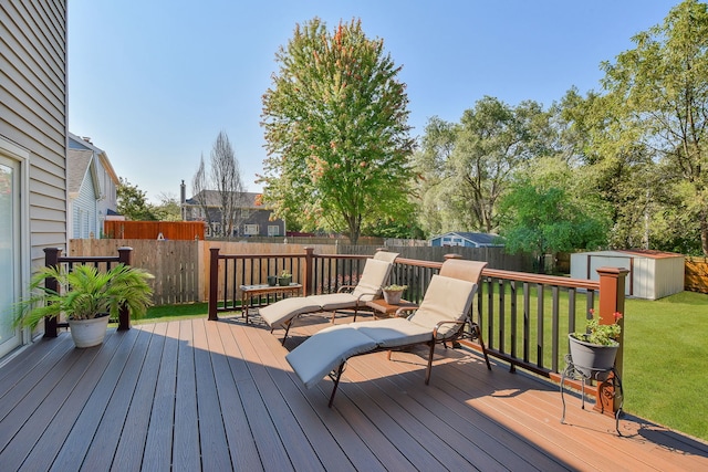 wooden terrace with a storage shed and a lawn