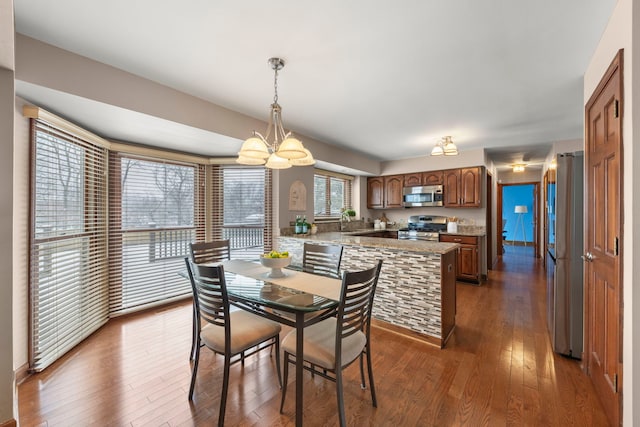 dining space with sink, a chandelier, and dark hardwood / wood-style floors