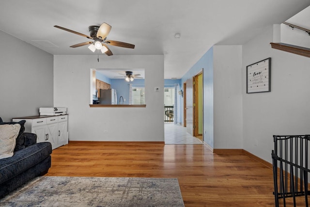 living room featuring ceiling fan and light wood-type flooring