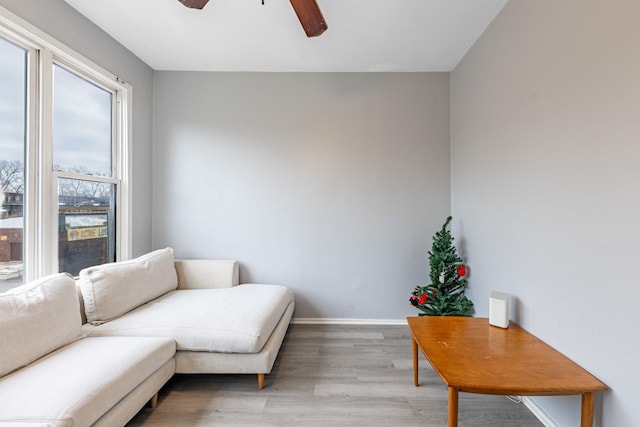 living area with hardwood / wood-style flooring and ceiling fan