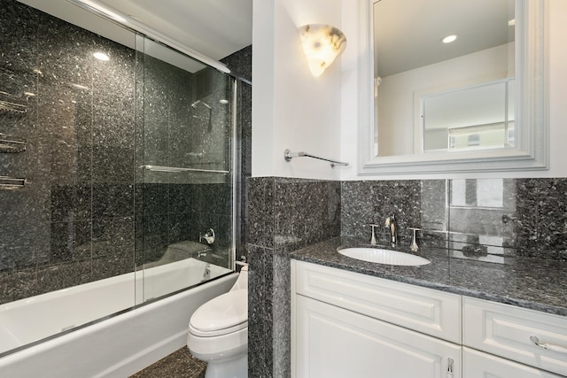 full bathroom with tasteful backsplash, enclosed tub / shower combo, toilet, vanity, and tile walls