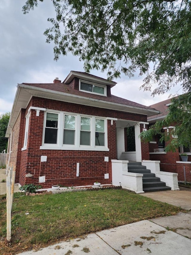 bungalow-style house with a porch and a front yard