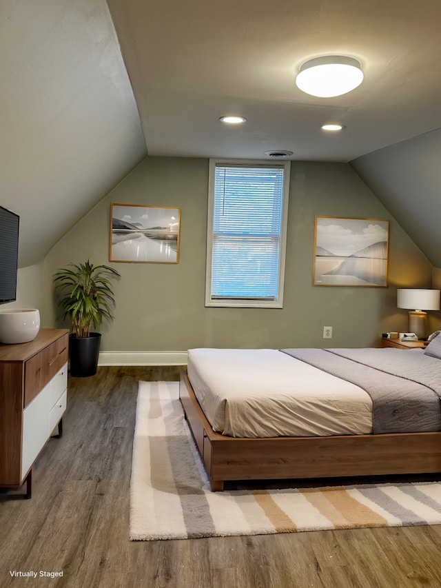 bedroom featuring hardwood / wood-style flooring and lofted ceiling