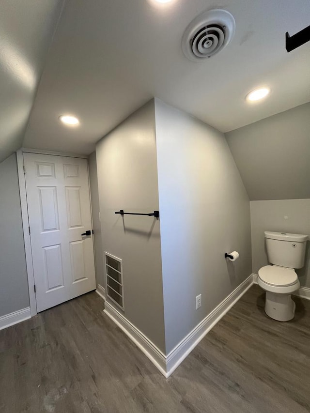 bathroom featuring hardwood / wood-style floors, toilet, and vaulted ceiling