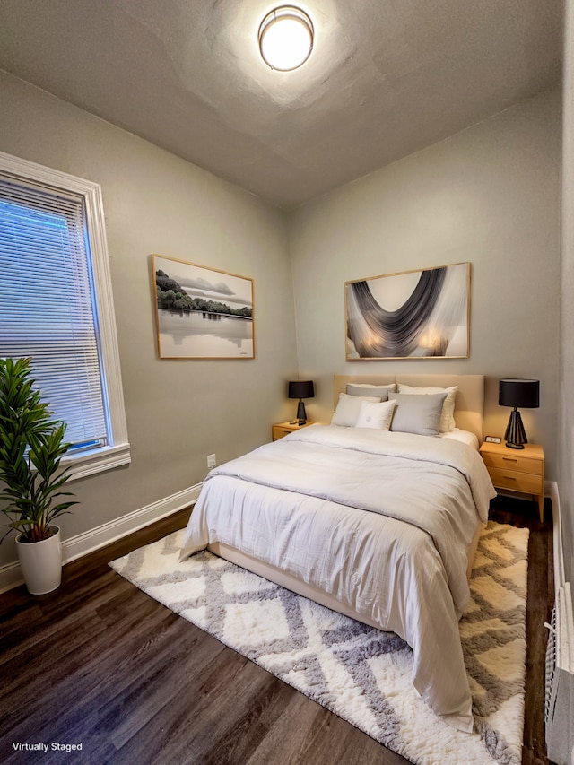 bedroom with dark hardwood / wood-style floors