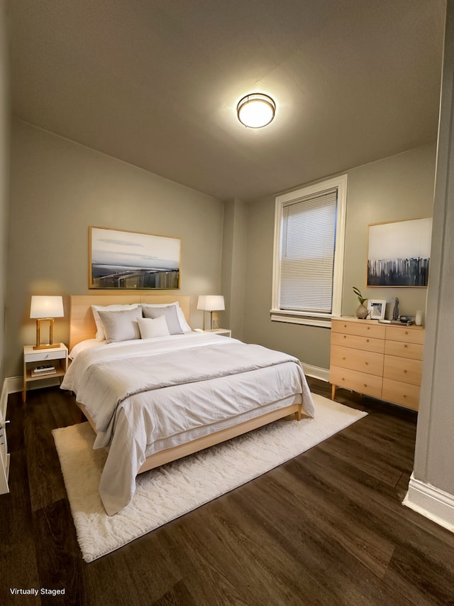 bedroom with dark hardwood / wood-style flooring