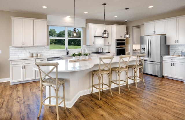 kitchen with pendant lighting, a center island, white cabinetry, and appliances with stainless steel finishes