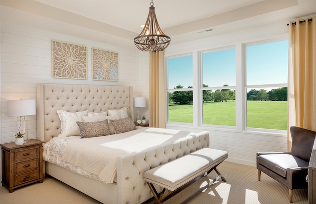 bedroom featuring light colored carpet and a notable chandelier