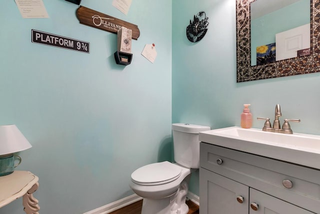 bathroom with vanity, toilet, and wood-type flooring