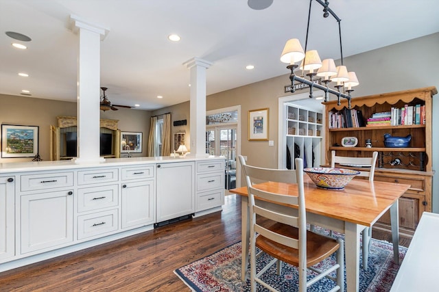 dining space with ceiling fan, dark hardwood / wood-style flooring, and ornate columns