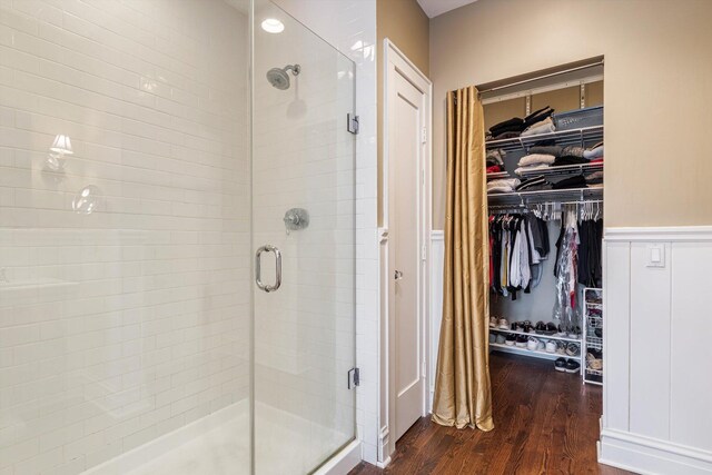 bathroom with a shower with shower door and wood-type flooring