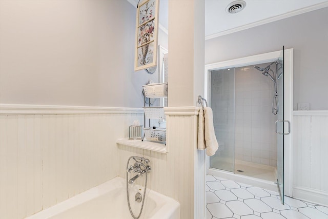 bathroom with ornamental molding and shower with separate bathtub