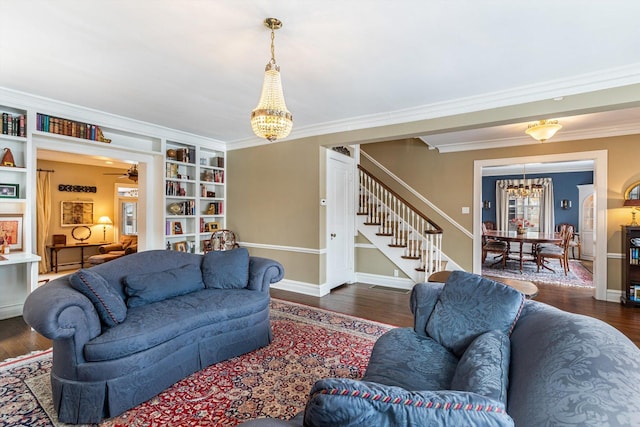 living room featuring built in features, a chandelier, dark hardwood / wood-style floors, and ornamental molding