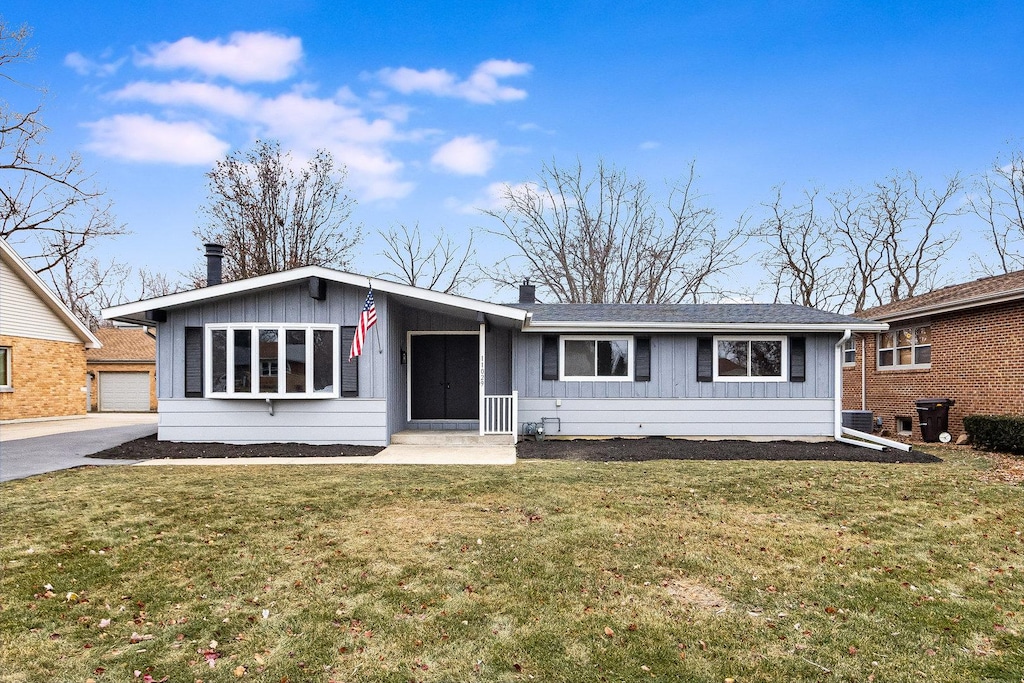 ranch-style home featuring a garage and a front lawn