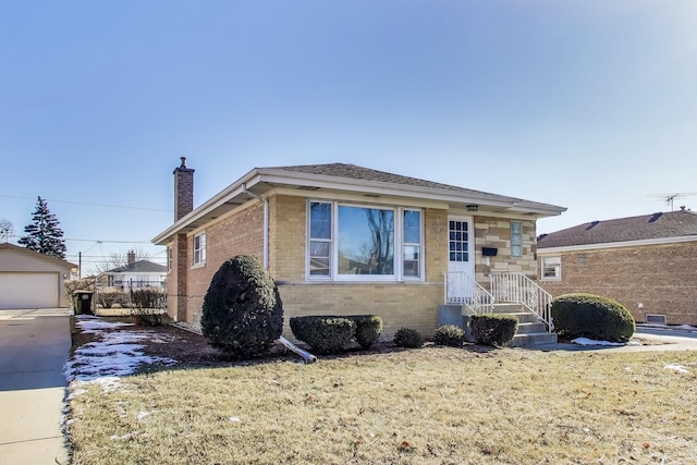 bungalow-style home featuring a garage, an outdoor structure, and a front lawn