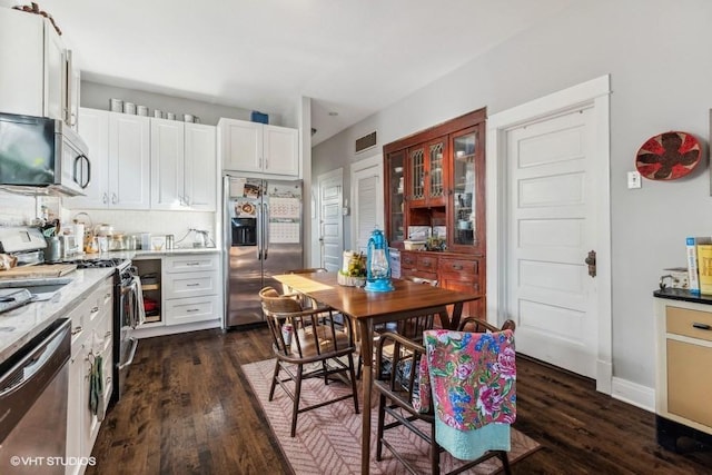 kitchen featuring white cabinetry, dark hardwood / wood-style flooring, and stainless steel appliances