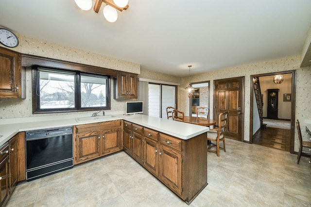 kitchen with kitchen peninsula, sink, dishwasher, and hanging light fixtures