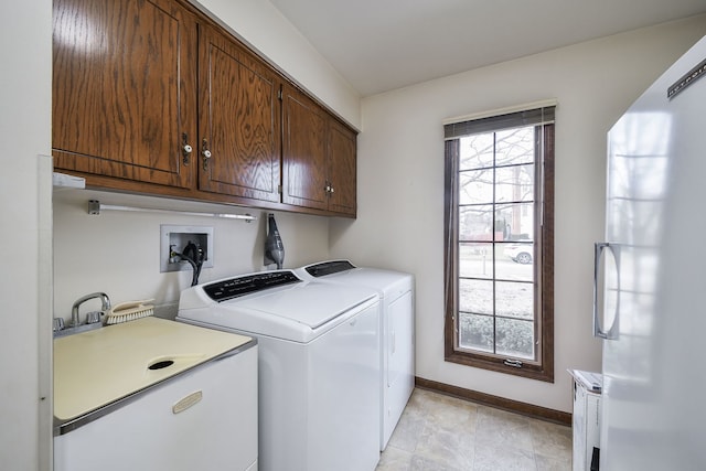 washroom featuring cabinets, sink, and independent washer and dryer