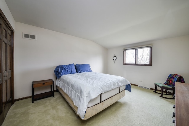 carpeted bedroom with a closet and vaulted ceiling