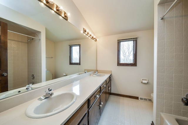 full bathroom with vanity, tiled shower / bath combo, plenty of natural light, and lofted ceiling