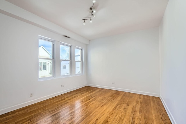 spare room featuring light hardwood / wood-style floors and track lighting