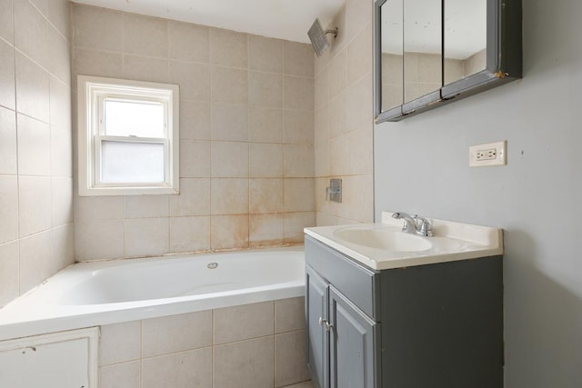 bathroom with vanity and tiled tub